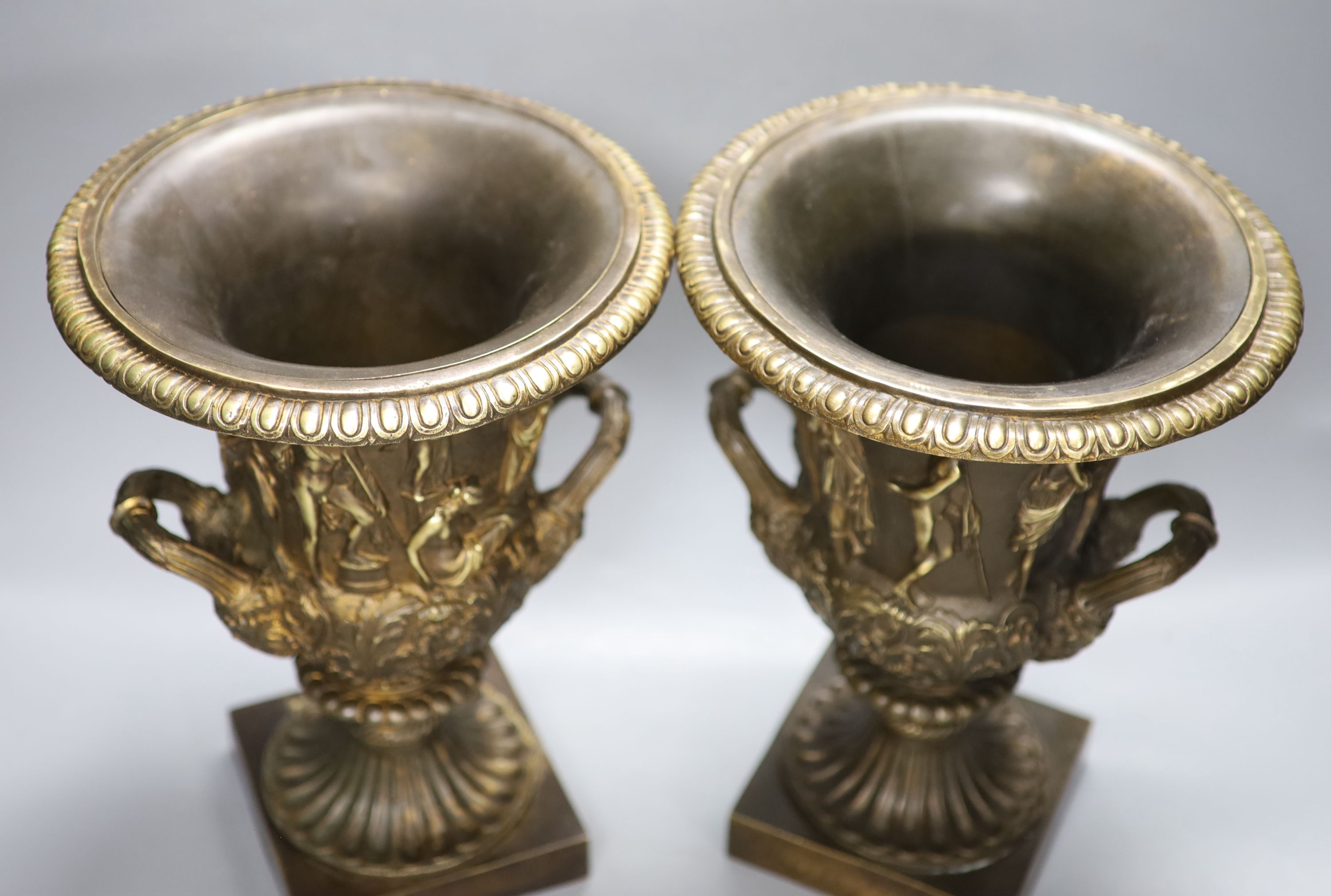 After the antique. A pair of bronze two handled Campana shaped urns, height 32cm